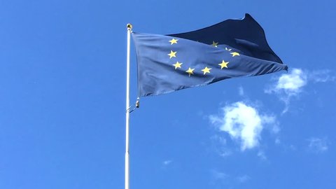 Flag of European union in the windy weather. Blue color background