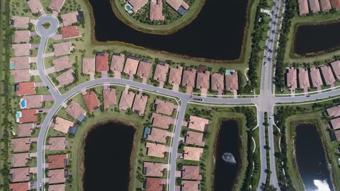Aerial shot of homes in a residential area in the suburbs of Florida. Aerial view of waterside houses in a gated community.