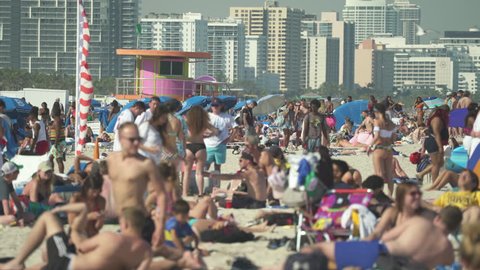 Crowded Miami South Beach at spring break time. Beach full of people in a sunny day - April 2018: Miami, Florida, US