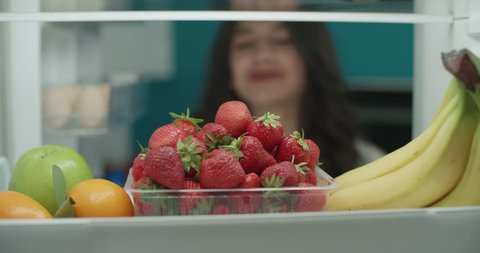 young attractive asian woman searching in fridge for fruits 4k - diet, healthy way of life concept