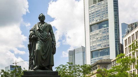 Memorial of the famous german literary Johann Wolfgang von Goethe in Frankfurt Germany. Time Lapse in front of blue sky and some clouds, low angle view. - Frankfurt Germany, Goetheplatz, June 3th 2018