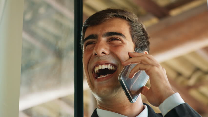 Confident Businessman In A Phone Call Having A Happy Conversation Smiling | Shutterstock HD Video #1012558307