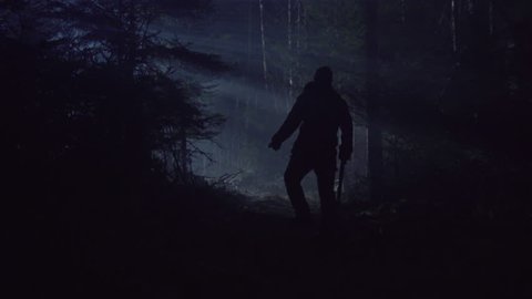CREEPY MAN WALKS THROUGH DARK FOREST WITH AXE