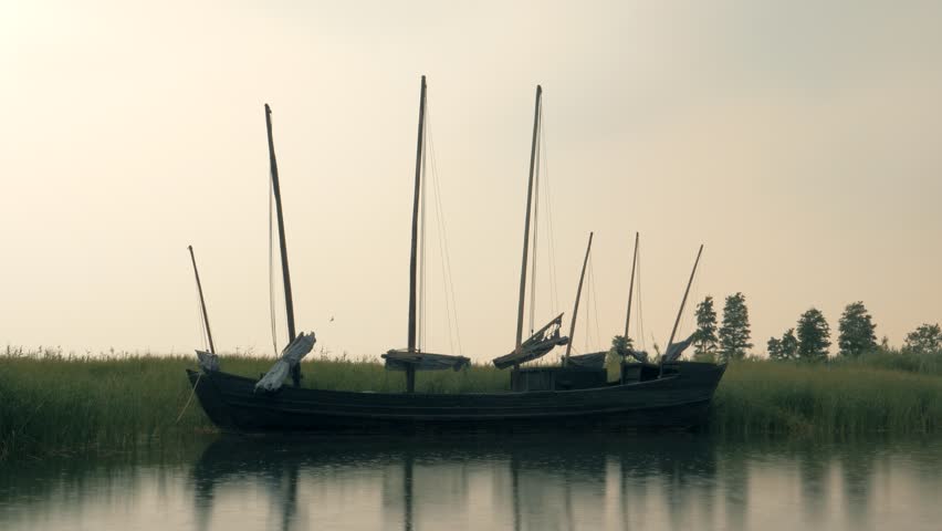 Abandoned fishing sailboat on the lake on rainny day