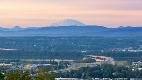 Time lapse movie of auto traffic on Glenn L. Jackson Memorial Bridge across Columbia River Gorge with sunset over snow covered Mt. St. Helens and Vancouver City in Washington State from Rocky Butte Vi