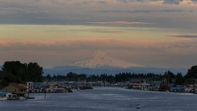 Time lapse video of moving clouds over snow covered mt. hood and Columbia river gorge with residential boathouses in Hayden Island 4k uhd 