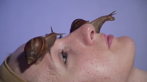 Two treatment snail achatina rejuvenate skin of woman in beauty salon