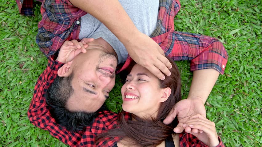 Romantic couple in park. Chinese asian man and woman in park relaxing and loving each other.