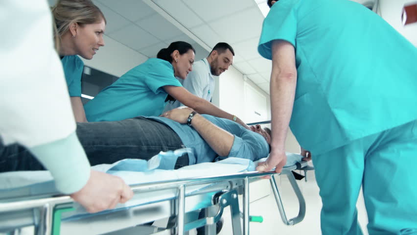 Emergency Department: Doctors, Nurses and Paramedics Run and Push Gurney / Stretcher with Seriously Injured Patient towards the Operating Room.  Shot on UHD 4K Camera.