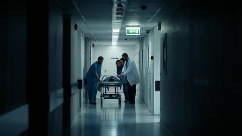 Emergency Department: Doctors, Nurses and Paramedics Run and Push Gurney with Seriously Injured Patient towards the Operating Room. Shot on RED EPIC-W 8K Helium Cinema Camera.