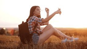 Hipster hiker silhouette girl traveler rest rest slow motion video with backpack doing take selfie self-portrait travel the blog. girl lifestyle selfie travel concept - Powered by Shutterstock - Get 15% off with code: PIKWIZARD15