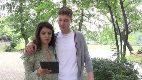 Couple in love walking in the city with tablet computer romantic young people 4K
