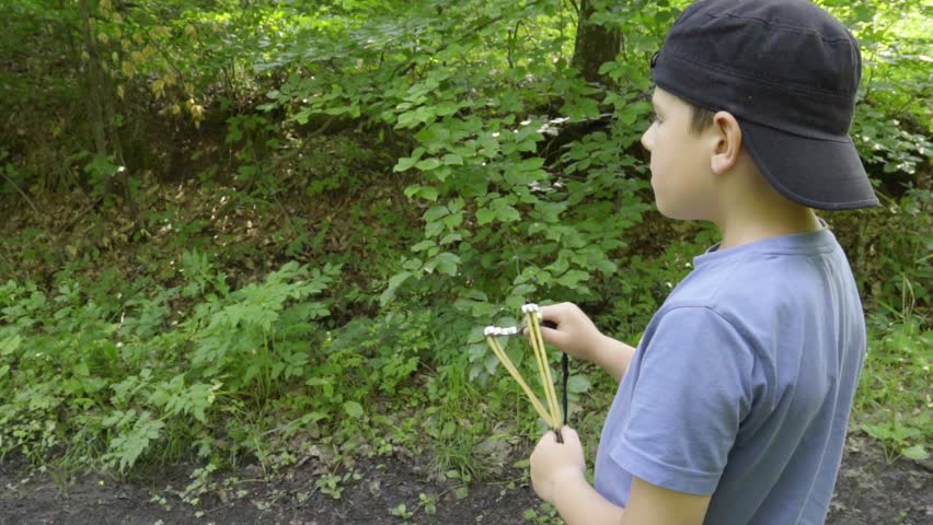 Boy playing with slingshot, slow motion