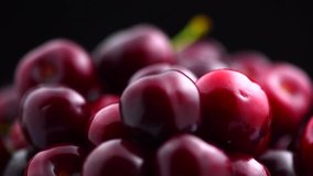 Fresh ripe Cherry close-up. Rotated Organic red cherries isolated on black background. Sweet Berries rotation. 4K UHD video