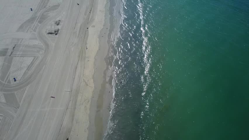 Aerial footage of empty, desolate beach in Southern California's Belmont Shore area of Long Beach