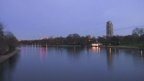 Dusk scene of The Serpentine lake in the Hyde Park with a view to the Hyde Park Barracks military base and London architecture buildings