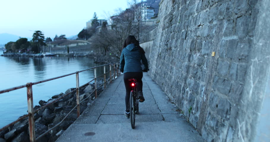 Girl going for bicycle ride during winter next to lake