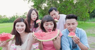 people eat watermelon happily and enjoy go on a picnic