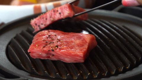 Cooking delicious juicy meat steaks on the grill on fire. Grillling premium beef Hida in Takayama Japan
