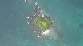 Aerial of private island with white sand beach surrounded by beautiful blue water from above - Ungraded Footage