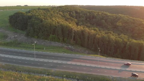 aerial view of a road with a stream of cars at sunset.