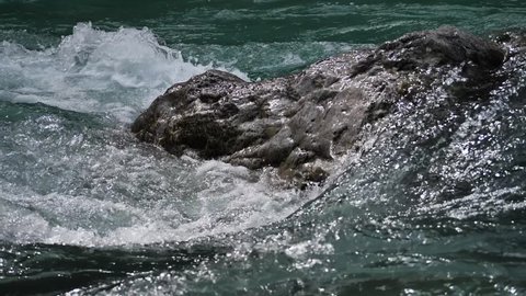 Water moving in a small river with rocks in slow motionwild river with rocks in slow motion