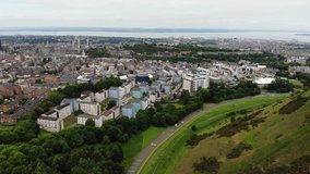 Aerial drone footage cityscape view of The Holyrood Park and buildings, Edinburgh, Scotland, United Kingdom.
