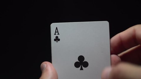 Gambler revealing four aces, player holding playing cards in his hands, concept of luck, black background.