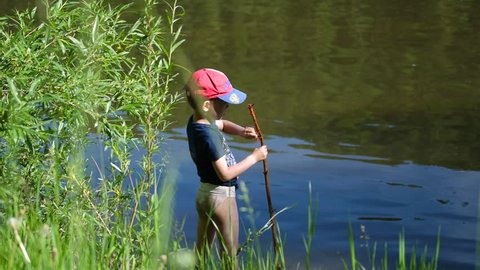 Two children catch fish with fishing rods on the river Bank. Beautiful summer landscape. Outdoor recreation.
