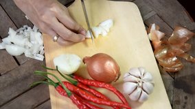 video footage hand slicing onion at cutting board