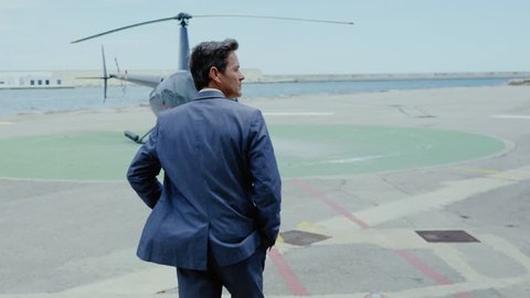 Businessman waiting near private helicopter