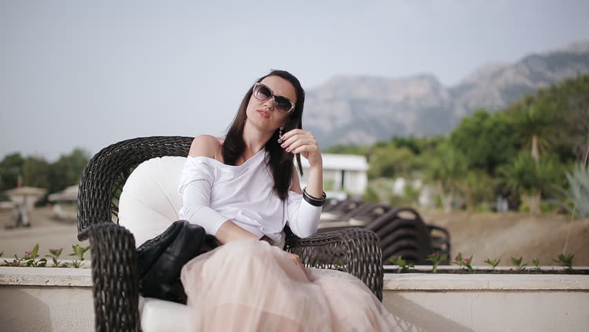 Attractive woman sitting in chair outdoors