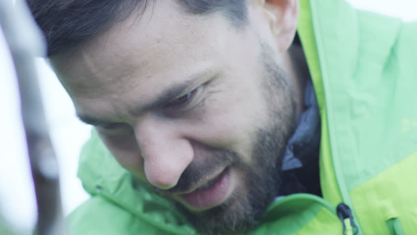 close up of logs as a fire begins, man in background