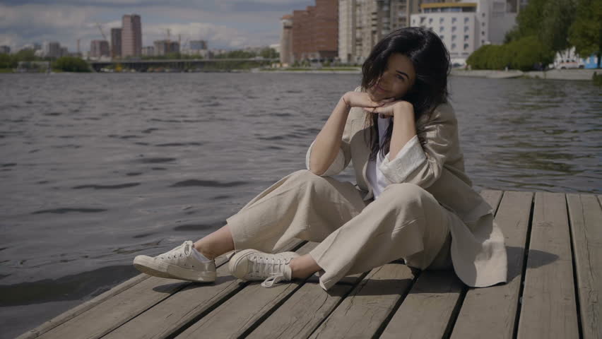 Girl is sitting by the water