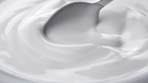 Closeup shot of mixing yogurt with spoon, Rotating
