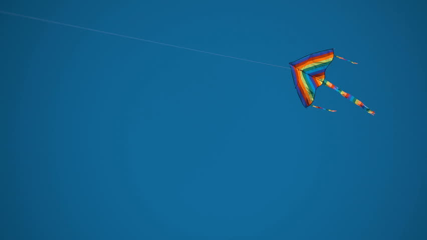 The kite flies in the blue sky. a kite flying in the blue sky.