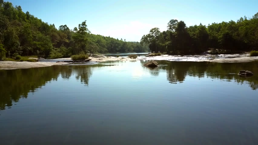 Aerial view tranquil river with clear sky reflection streams among wild landscape of green forest