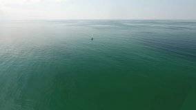 Drone shot flying towards a sailboat from a distance over mediterranean sea. Beautiful sunny afternoon, high altitude flight. Location france