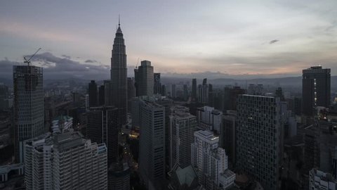 Beautiful time lapse of Kuala Lumpur city center overlooking the city skyline during sunset with zoom in and bottom to top pan.
