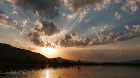 A colorful spring sunrise video from Akyaka coastline (Gulf of Gokova, Aegean Sea). The sun is rising behind the clouds, casting huge crepuscular rays.
