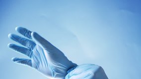 Doctor put on blue latex gloves, closeup - Powered by Shutterstock - Get 15% off with code: PIKWIZARD15