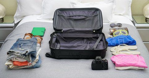4K stop motion animation of empty suitcase being filled up with women's clothes