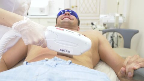 male laser hair removal. a doctor in white gloves removes hair from the abdomen and breasts of a man. 4k, close-up. Slow motion
