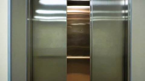 The elevator doors open. Opening the door is an elevator. Metal doors smoothly open.