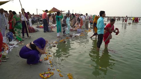woman in blue saree offering flowers to water of the holy rive Yamuna Jamuna   near Prayag Sangam area
Allahabad city Uttar Pradesh State / India
filmed on 29th May 2018