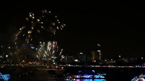 4K footage of real fireworks festival in the sky for celebration at night with city view at background and boat floating on the sea at foreground at coast side Stock Video