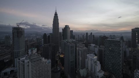 Beautiful time lapse of Kuala Lumpur city center overlooking the city skyline during sunset with diagonal bottom to top pan.