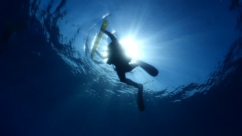scuba divers on the surface underwater
sun shine sun beams and rays with a safety sausage slow
