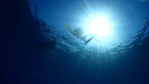 scuba divers on the surface underwater
sun shine sun beams and rays with a safety sausage buoy
