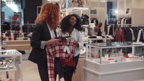 Smiling curly hair women shopping buy hold clothes at the box office at the clothing store